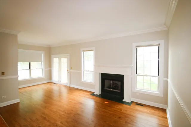 an empty room with windows and a fireplace