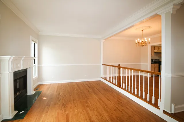 a view of a livingroom with wooden floor and a fireplace