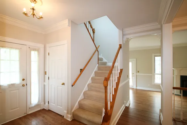 a view of a hallway with wooden floor and staircase