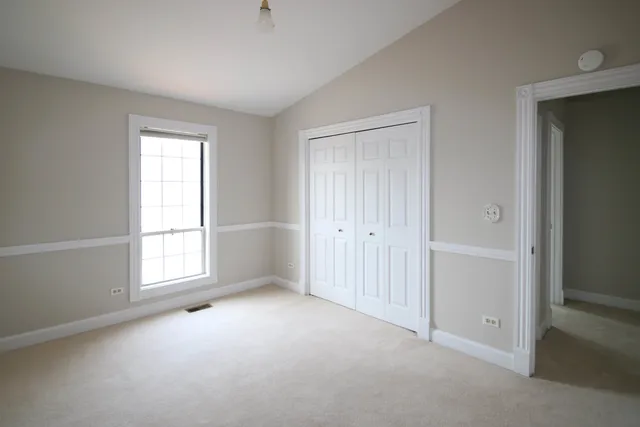 an empty room with windows and closet