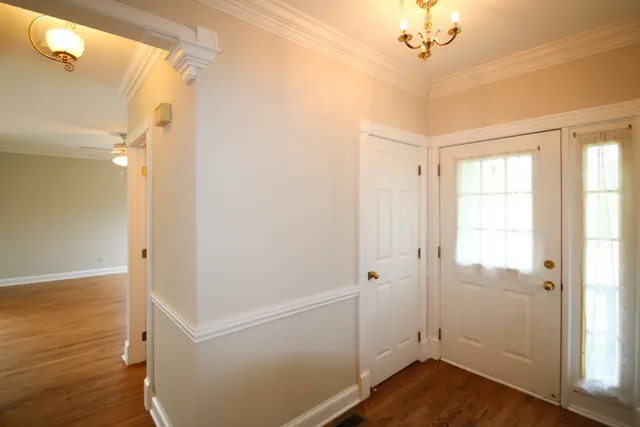 a view of a hallway with wooden floor and closet