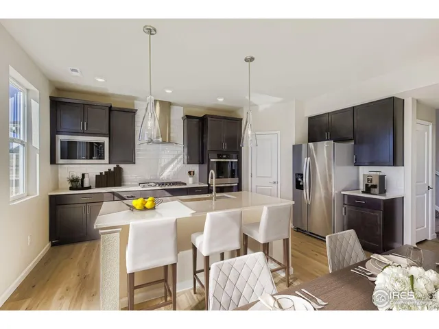 a kitchen with stainless steel appliances kitchen island granite countertop a refrigerator and a stove top oven