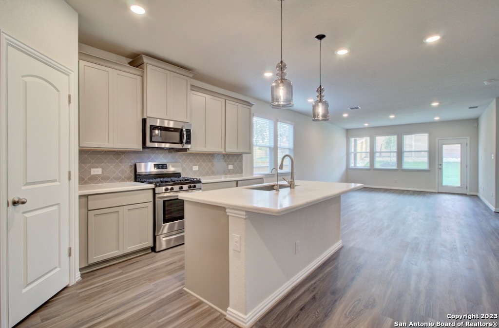a open kitchen with kitchen island a sink stainless steel appliances and cabinets