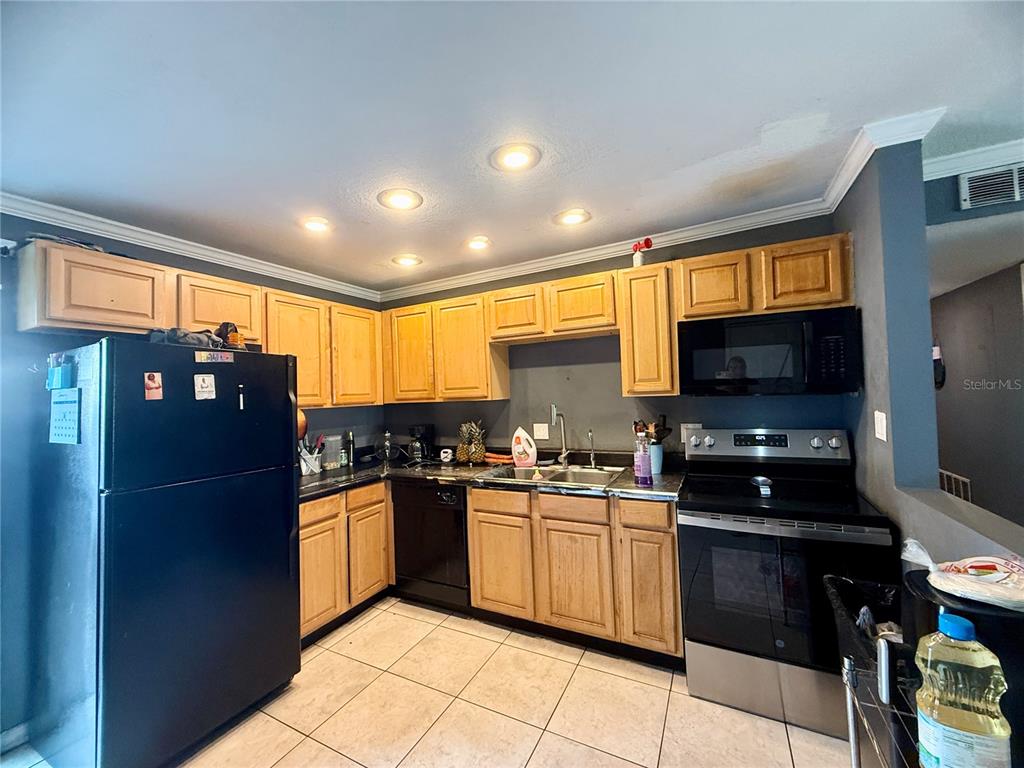 1944 South Conway Road, Unit 3 Orlando, FL 32812 - Photo 4 of 20 a kitchen with stainless steel appliances granite countertop a stove a sink and a refrigerator