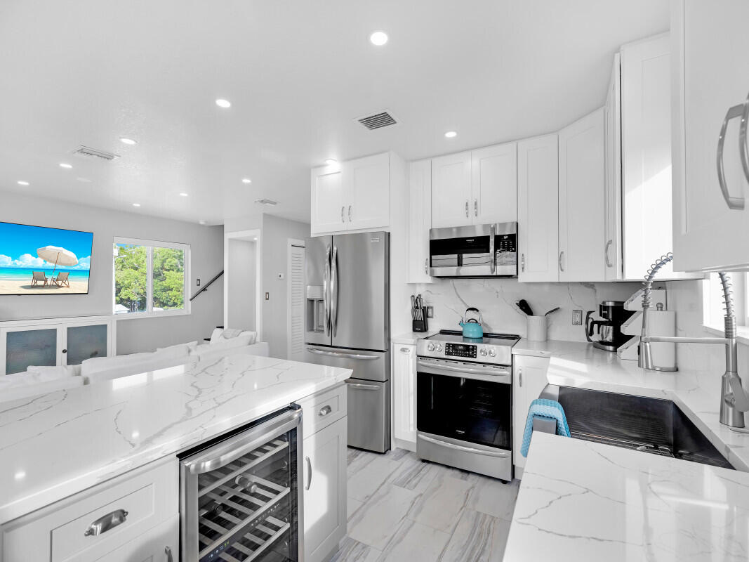325 Calusa Street, Unit 359 Key Largo, FL 33037 - Photo 4 of 52 a kitchen with a sink white cabinets and stainless steel appliances