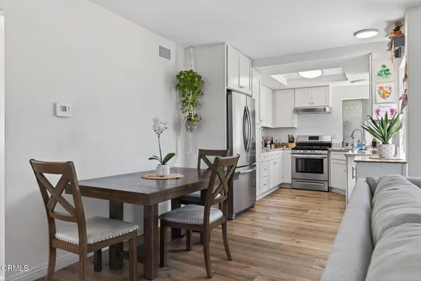 a kitchen with granite countertop white cabinets and stainless steel appliances