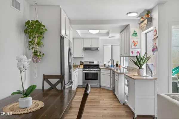 a kitchen with stainless steel appliances a counter space a sink and cabinets
