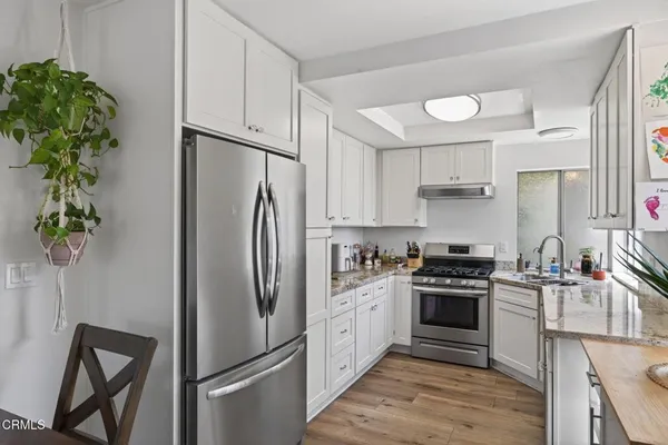 a kitchen with stainless steel appliances a refrigerator sink and stove