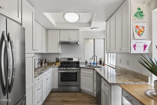 a kitchen with stainless steel appliances granite countertop a sink stove and refrigerator