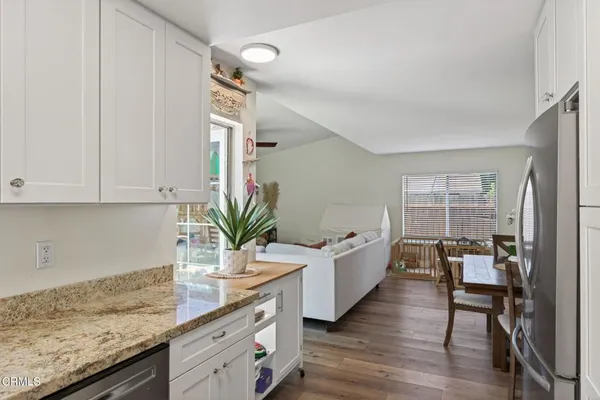 a kitchen with granite countertop a sink chairs and cabinets