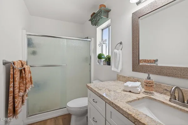 a bathroom with a granite countertop sink toilet and shower