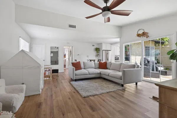 a living room with furniture and a wooden floor