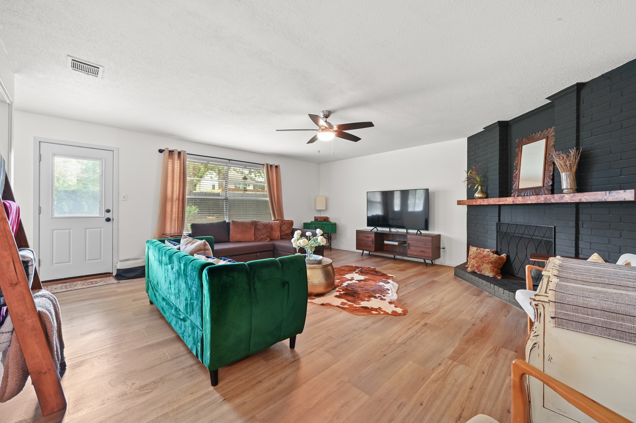 6805 Rearden Road Austin, TX 78745 - Photo 3 of 26 A welcoming living area boasts durable hardwood flooring and a cozy fireplace, perfect for relaxation.