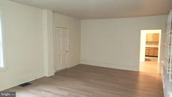 an empty room with wooden floor and a window