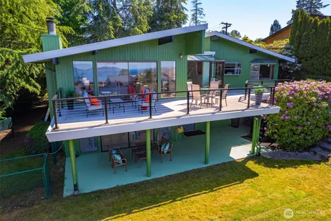 an aerial view of a house with a swimming pool a yard and mountain view
