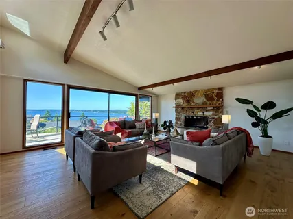 a living room with furniture floor to ceiling window and wooden floor