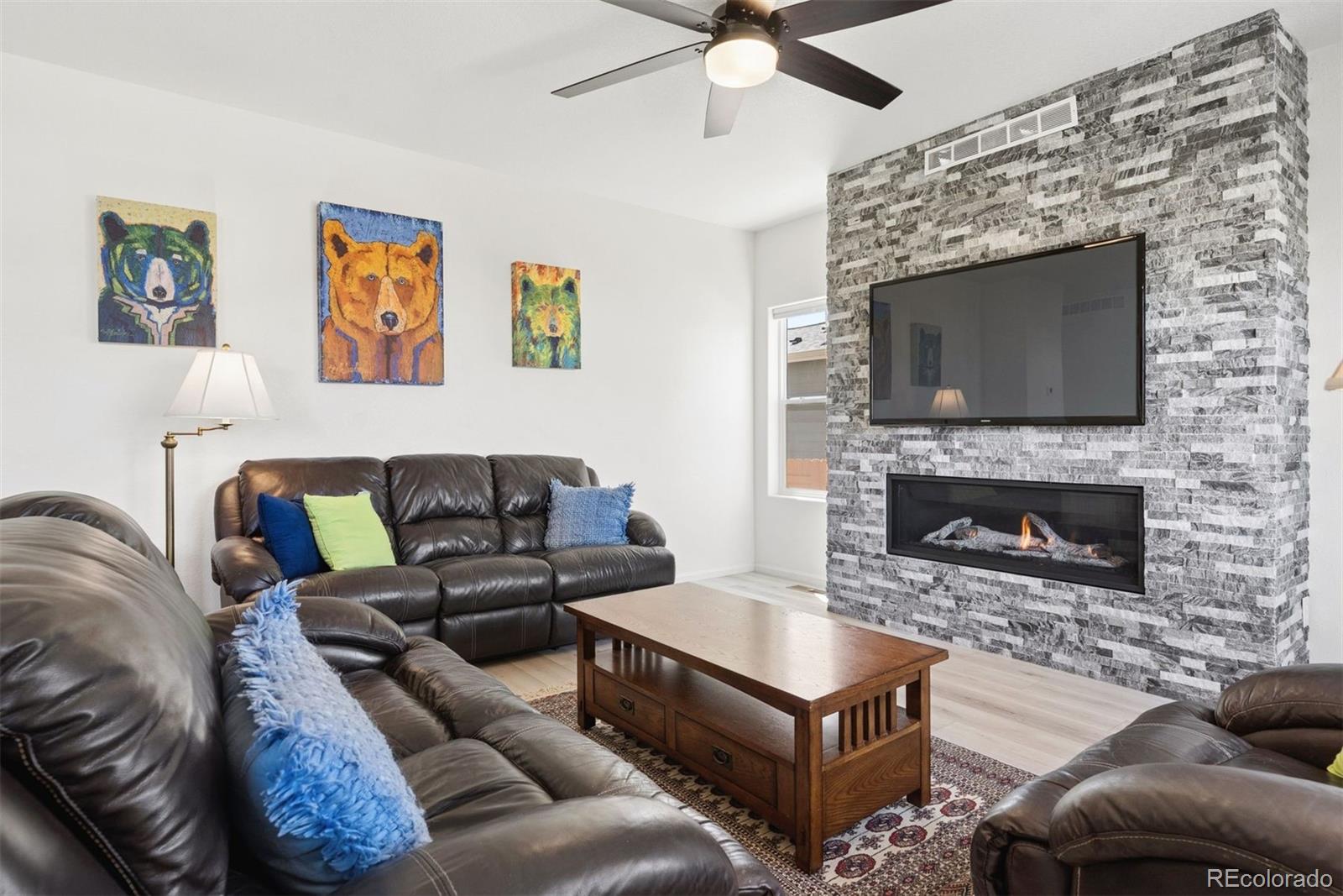 7307 Animas Avenue Frederick, CO 80530 - Photo 13 of 49 a living room with furniture a flat screen tv and a fireplace