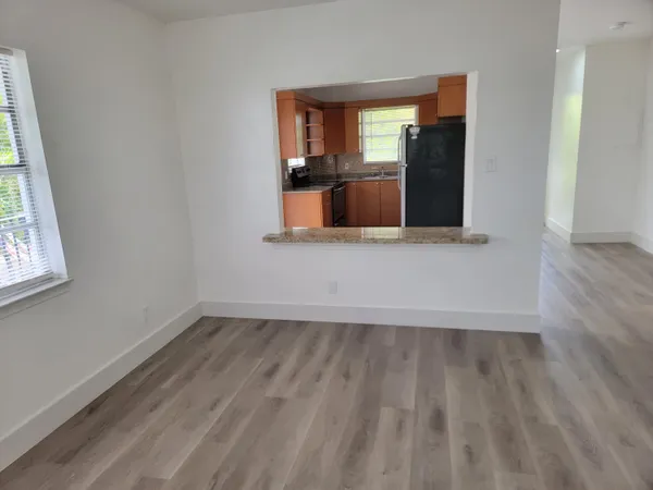 an empty room with wooden floor and a window