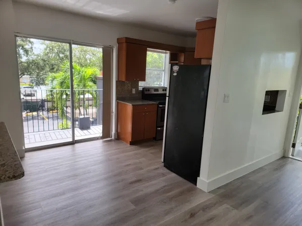 a view of a kitchen with wooden floor and refrigerator