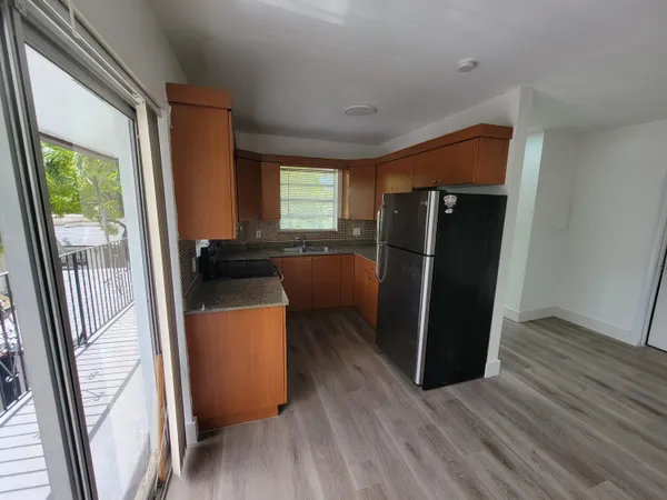 a kitchen with a refrigerator and wooden floor