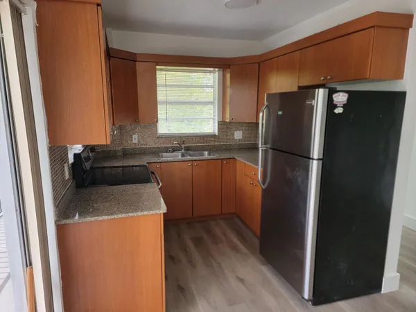 a kitchen with a refrigerator sink and cabinets