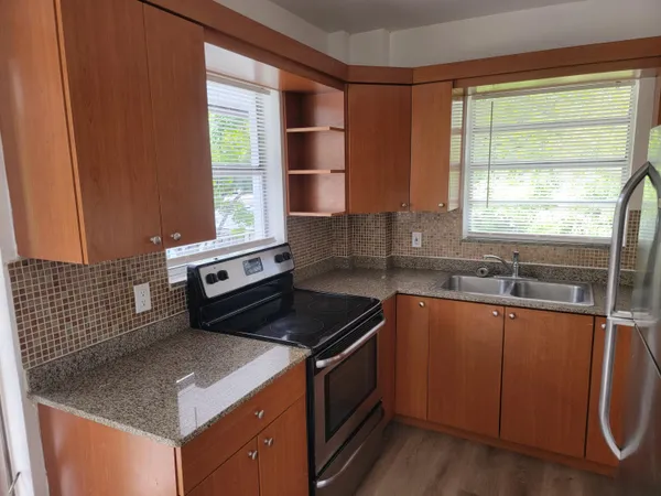 a kitchen with granite countertop a sink stove and cabinets