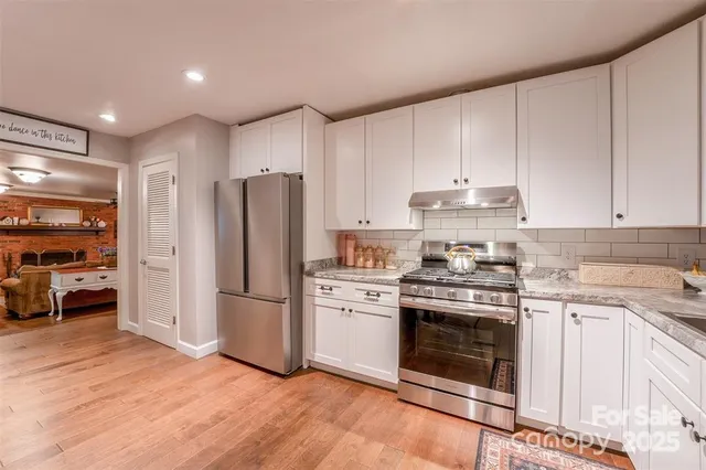 a kitchen with a stove top oven and refrigerator
