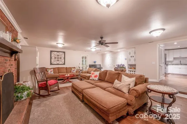 a living room with furniture a fireplace and a chandelier