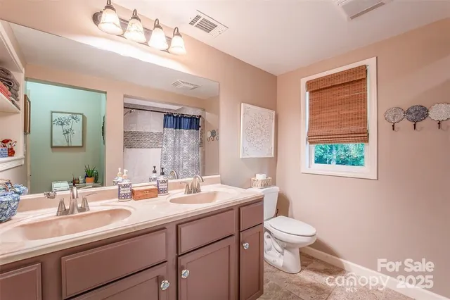 a bathroom with a double vanity sink a toilet and a mirror