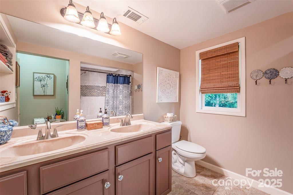 4805 Nesbit Road Monroe, NC 28112 - Photo 21 of 40 a bathroom with a double vanity sink a toilet and a mirror