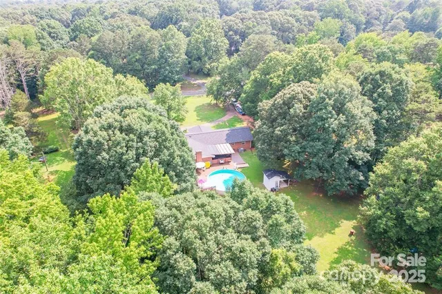 an aerial view of a house with a yard and swimming pool
