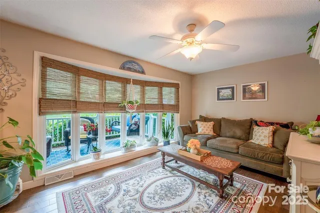 a living room with furniture and a large window with wooden floor
