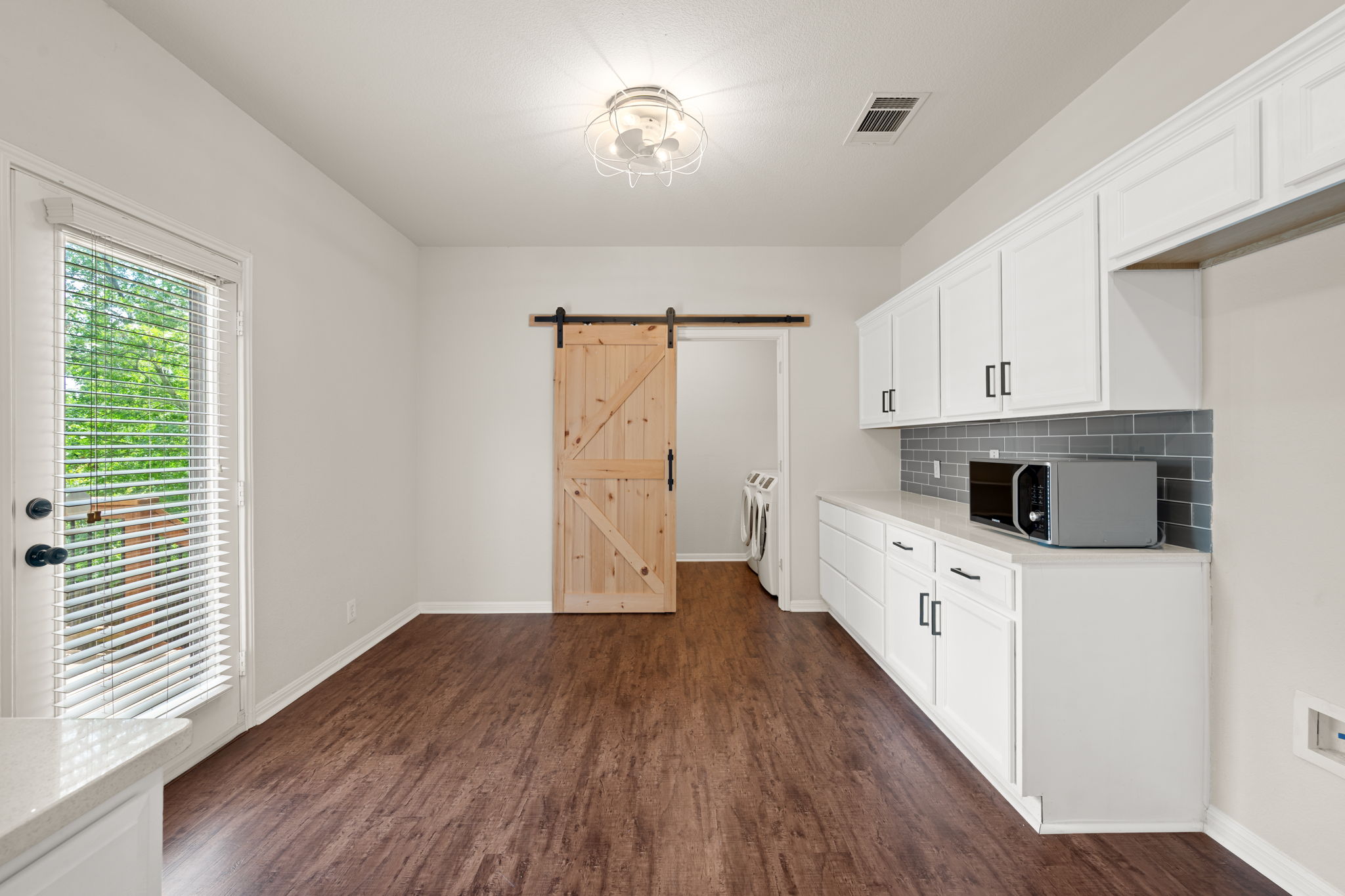 8902 Magna Carta Loop, Unit 122 Austin, TX 78754 - Photo 12 of 39 A well-lit laundry area boasts ample storage with white cabinetry and a convenient sliding barn door.