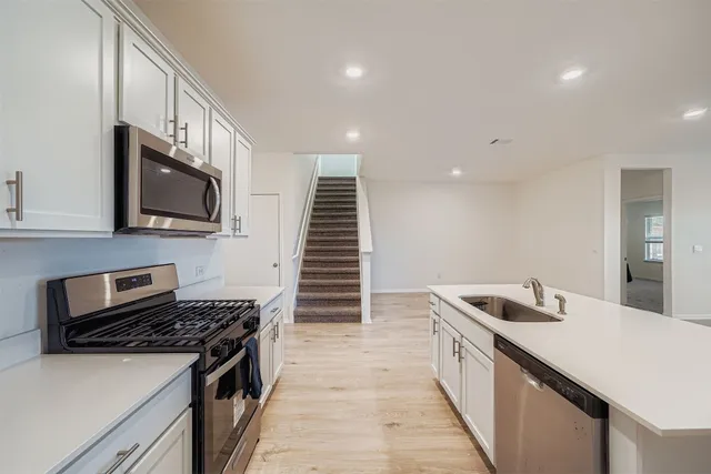 a kitchen with white cabinets and stainless steel appliances