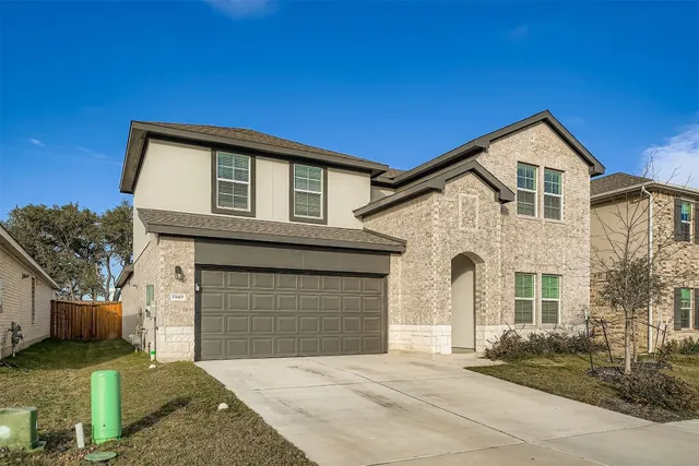 a front view of a house with a yard and garage