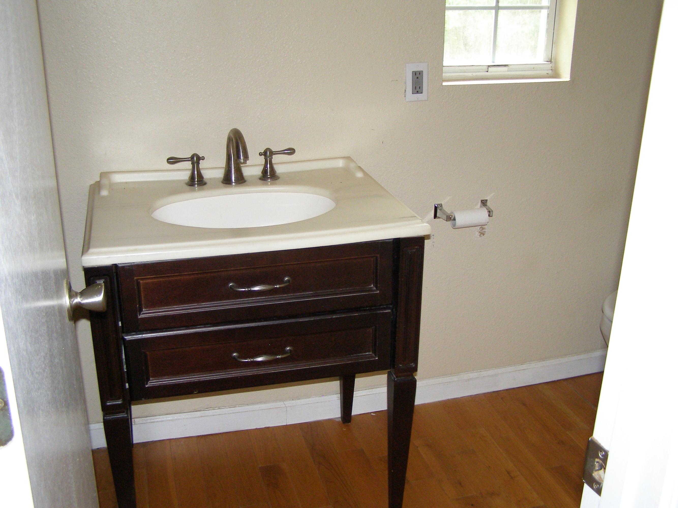 84 Roberts Road East DeFuniak Springs, FL 32433 - Photo 15 of 18 a bathroom with a sink a mirror and wooden floor