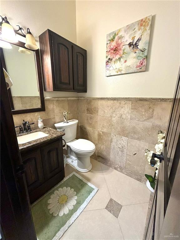 336 Navarro Street Pharr, TX 78577 - Photo 16 of 32 Half bathroom with vanity, tile walls, and a wainscoted wall