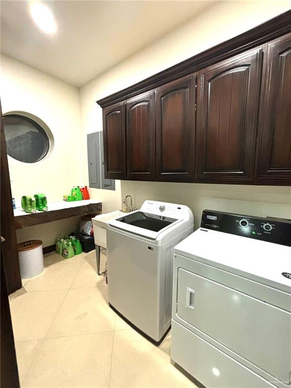336 Navarro Street Pharr, TX 78577 - Photo 18 of 32 Laundry room with washer and dryer, cabinet space, electric panel, and light tile patterned floors