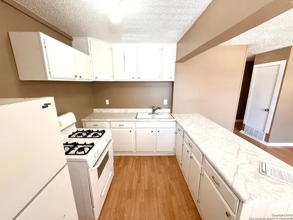 a kitchen with a sink a stove and refrigerator