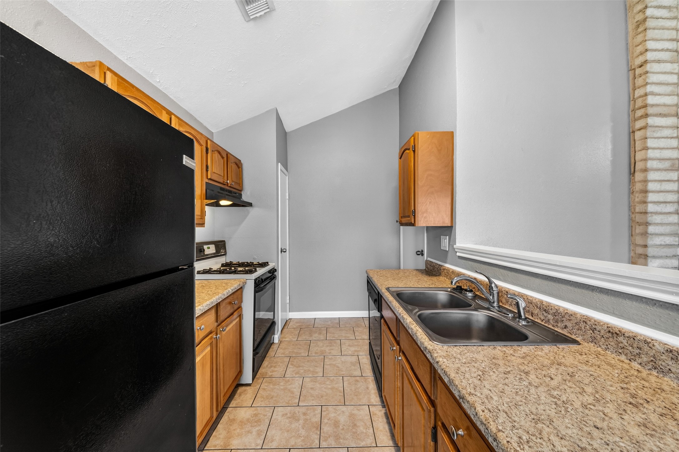 3119 Oak Rock Spring, TX 77373 - Photo 11 of 25 a kitchen with a sink stove and refrigerator