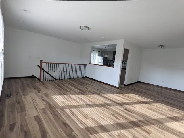 a view of a room with wooden floor and window