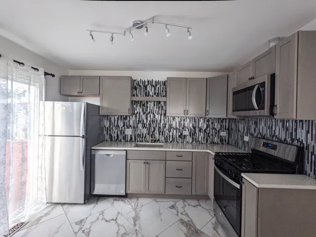 a kitchen with a sink a refrigerator and a stove top oven