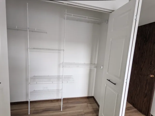 a view of a hallway with wooden floor and glass door