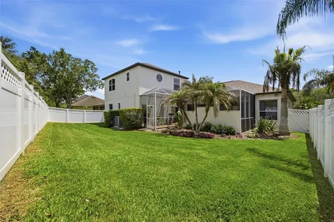 a view of a house with backyard and a tree