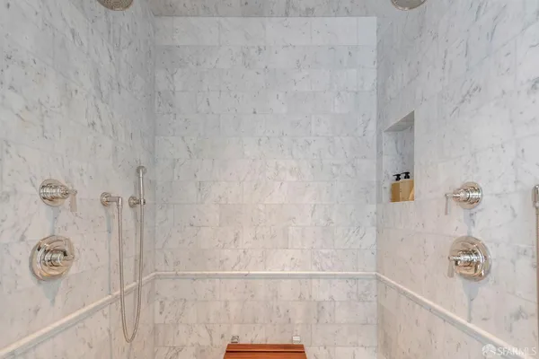 a view of a hallway with wooden floor and a bathroom