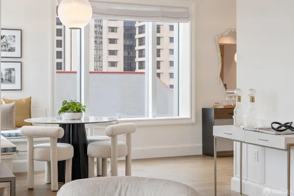 a living room with stainless steel appliances granite countertop furniture and a large window