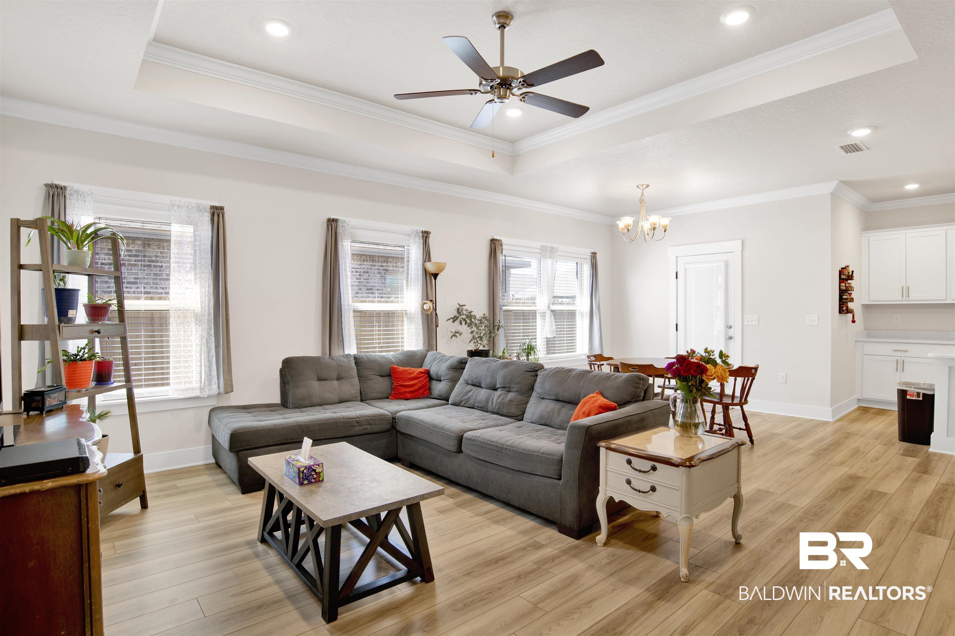 1174 Pheasant Circle Foley, AL 36535 - Photo 6 of 29 Living room with a ceiling fan, crown molding, light wood finished floors, suspended lighting, and a raised ceiling