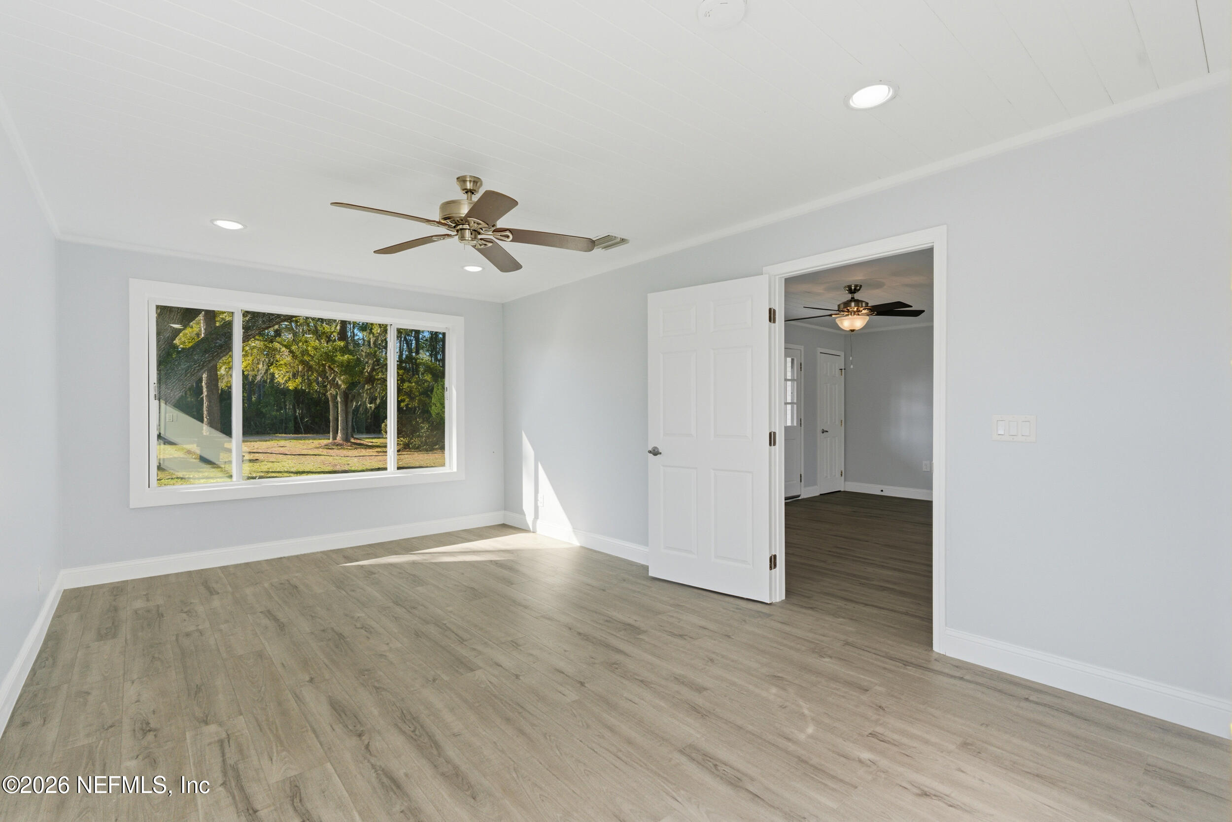 97150 Caravel Trail Yulee, FL 32097 - Photo 19 of 35 an empty room with wooden floor and a ceiling fan
