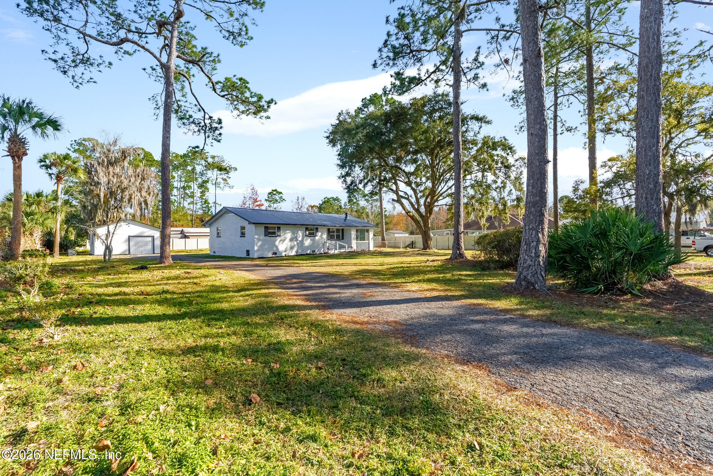 97150 Caravel Trail Yulee, FL 32097 - Photo 2 of 35 a view of a swimming pool with a lawn chairs under palm trees