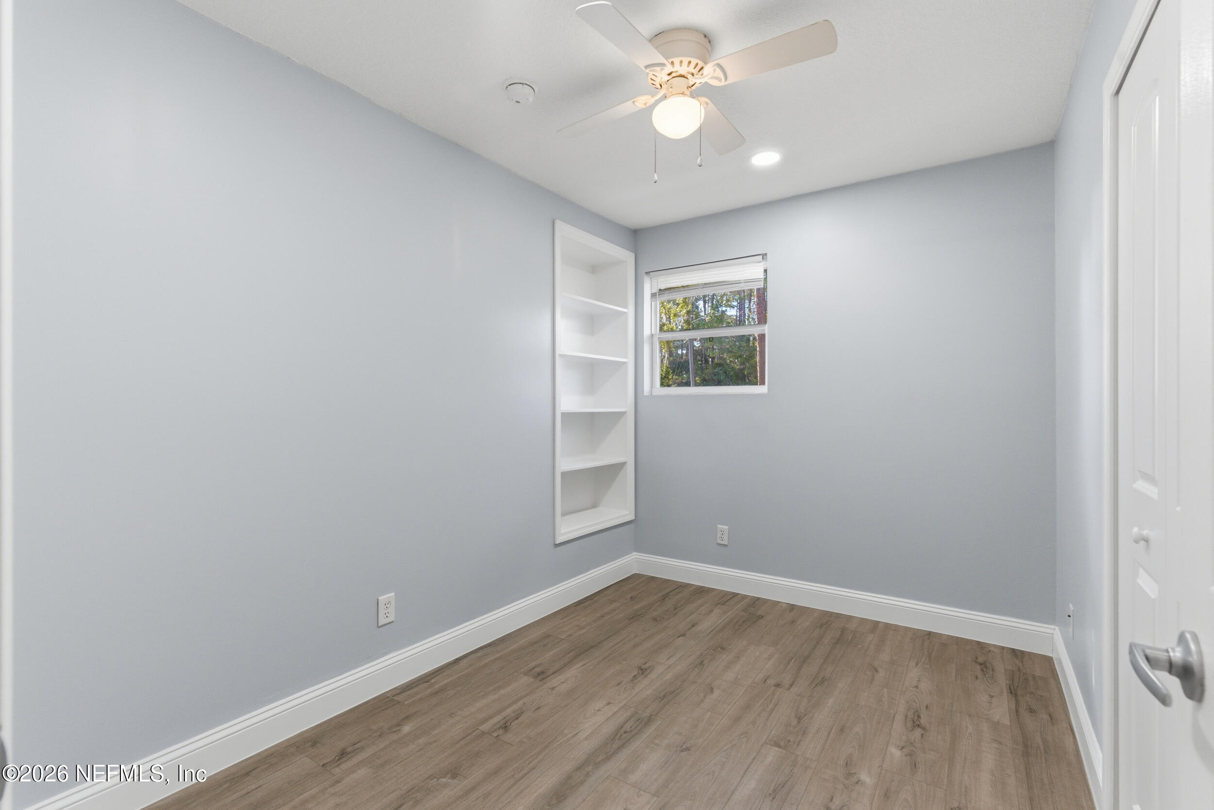 97150 Caravel Trail Yulee, FL 32097 - Photo 24 of 35 an empty room with wooden floor and windows